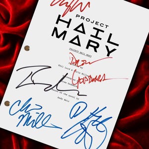 May include: A white script titled "PROJECT HAIL MARY" with multiple signatures in red, black, and blue ink. The script is on a red velvet surface. The text includes "Directed by Phil Lord & Chris Miller" and "Based on the novel by Andy Weir."