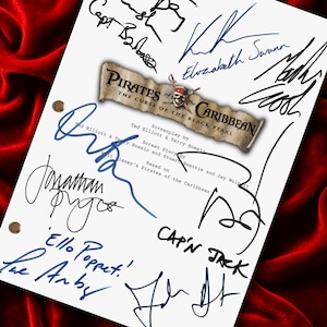 May include: A white screenplay title page for Pirates of the Caribbean: The Curse of the Black Pearl, featuring multiple black and blue ink signatures and inscriptions including Cap'n Jack and Ello Poppet, with three metal binder holes on the left side.