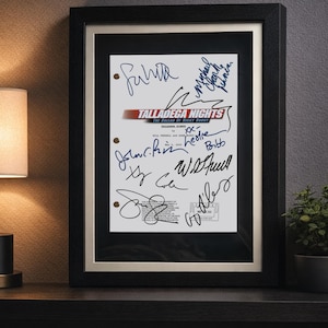 May include: A framed script cover for the film Talladega Nights: The Ballad of Ricky Bobby, featuring multiple black and blue ink signatures. The document is white with red and black text, secured in a black frame with a light-coloured matting.