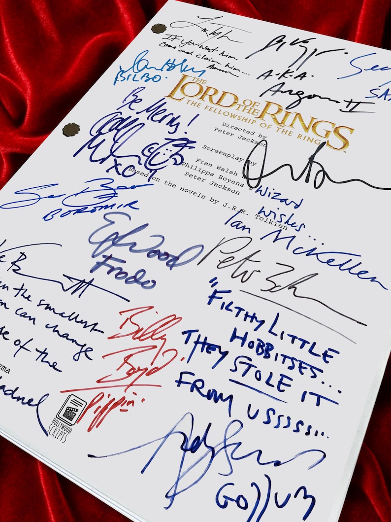 Puede incluir: Un guion blanco de "El Se&ntilde;or de los Anillos: La Comunidad del Anillo" con m&uacute;ltiples firmas en tinta azul y roja. El t&iacute;tulo est&aacute; en letras doradas. El guion est&aacute; sobre un fondo de terciopelo rojo.