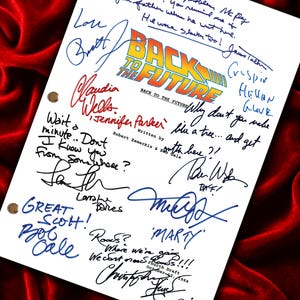 Pode incluir: Uma página de roteiro de filme branca para Back to the Future com o logotipo do filme, créditos de produção e a data 12 de outubro de 1984. A página contém citações manuscritas e várias assinaturas em tinta azul, vermelha e preta.