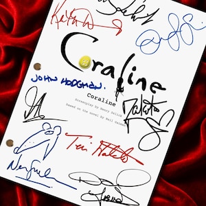May include: A white sheet with the title "Coraline" in black script, surrounded by colorful signatures. A yellow button is placed above the title. The sheet is set against a red velvet background.