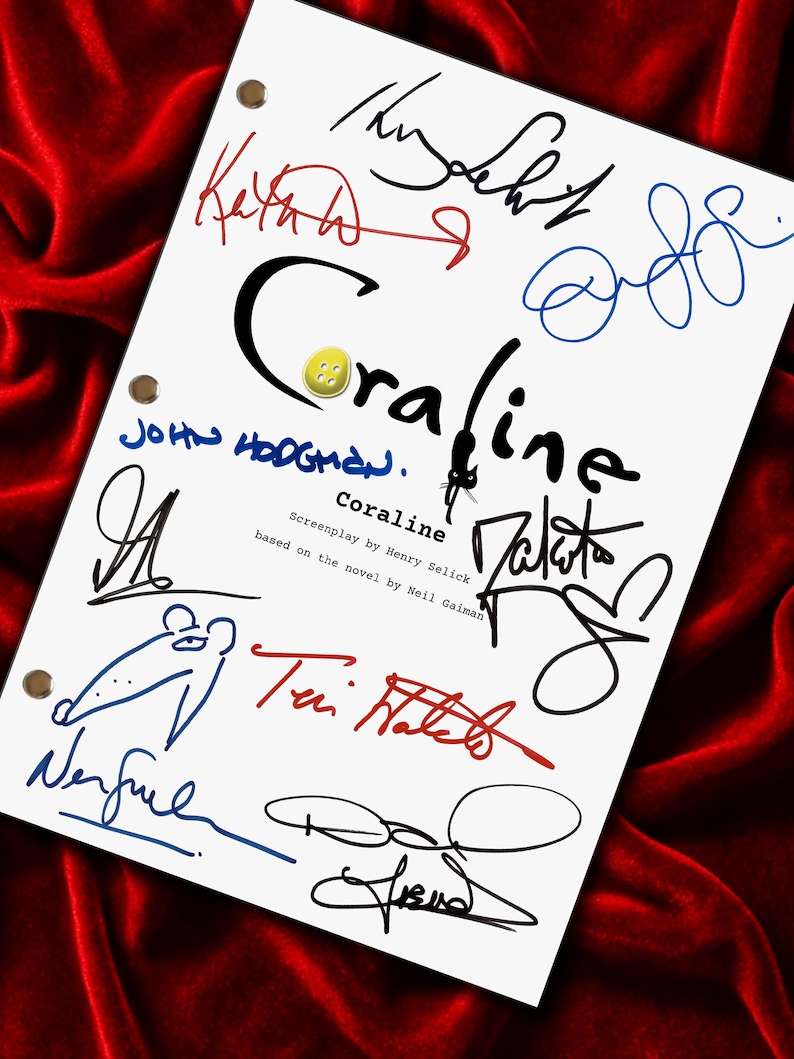 May include: A white sheet with the title "Coraline" in black script, surrounded by colorful signatures. A yellow button is placed above the title. The sheet is set against a red velvet background.