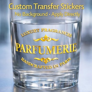 Könnte beinhalten: Ein klares Glas mit goldfarbenen Buchstaben, die "Luxury Fragrances Parfumerie Handcrafted in Paris" lesen. Der Text "Custom Transfer Stickers No Background Apply Directly" steht über dem Haupttext. Das Glas ist mit einer klaren Flüssigkeit gefüllt.