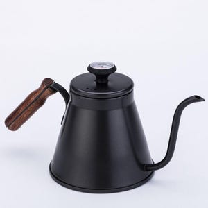 May include: A black gooseneck kettle with a wooden handle and a thermometer on the lid. The kettle has a long, curved spout for precise pouring. The handle is made of light brown wood. The kettle is designed for brewing coffee or tea.