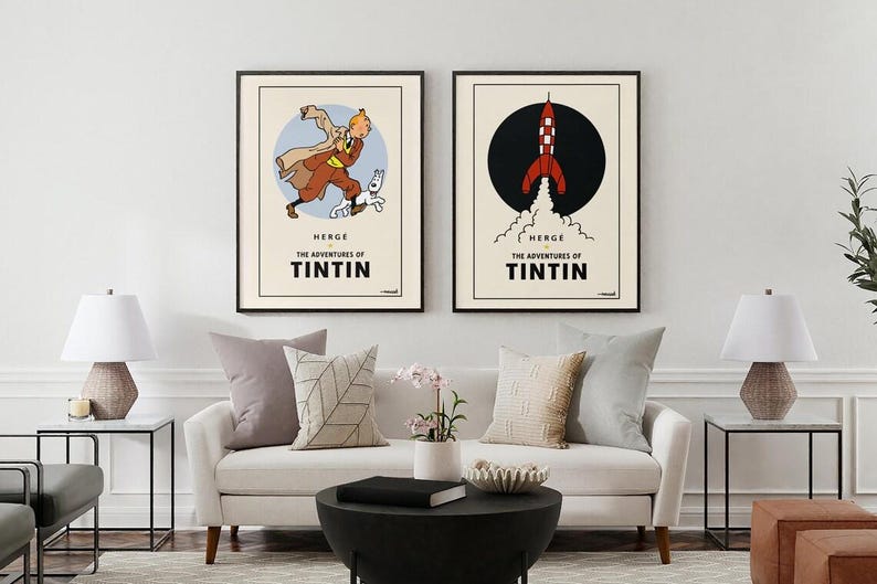 Puede incluir: Dos carteles enmarcados con ilustraciones de Las aventuras de Tint&iacute;n. Uno muestra a Tint&iacute;n con Mil&uacute;, el otro un cohete. Ambos tienen un fondo crema con marcos y texto negros.