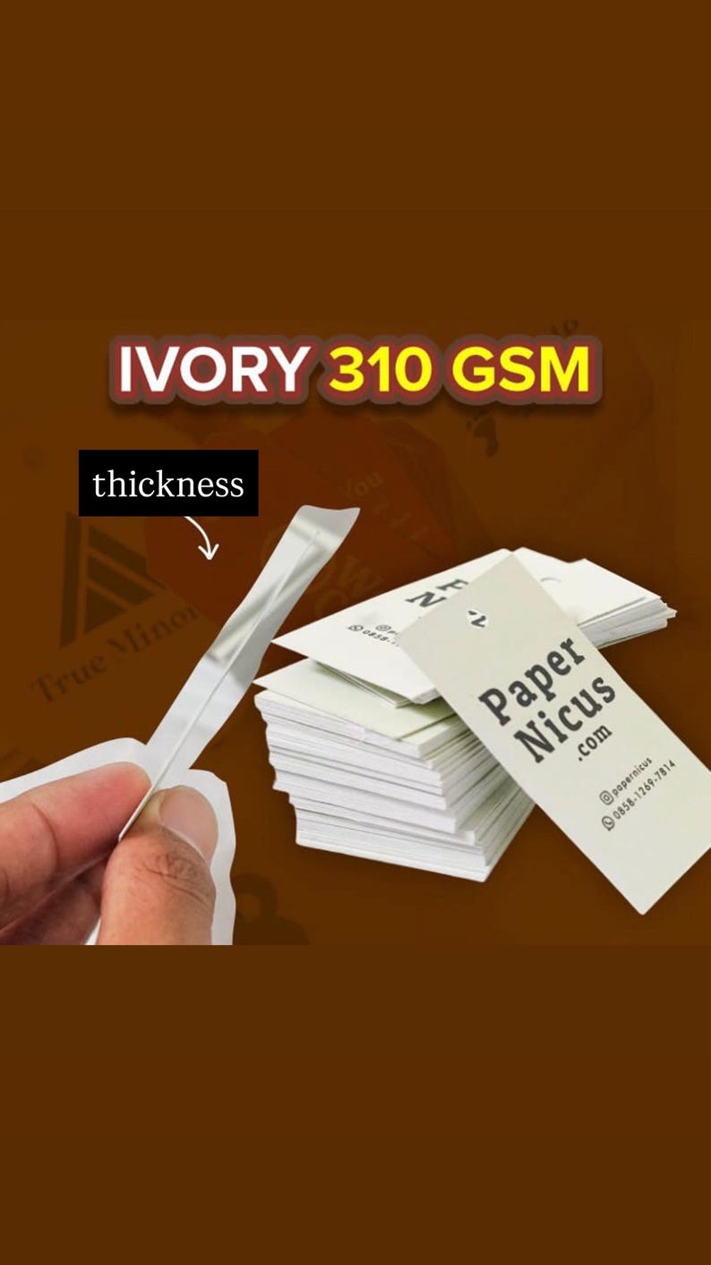 May include: A stack of white rectangular business cards labeled Paper Nicus .com with contact details. A single card is held up to show its thickness. The text IVORY 310 GSM is displayed at the top, and an arrow points to the card edge labeled thickness.