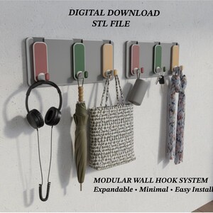 May include: A modular wall hook system with multiple hooks in a row, holding various items. Items include black headphones, a green umbrella, a patterned tote bag, a gray tumbler, and patterned scarves. Text at the top reads "DIGITAL DOWNLOAD STL FILE".