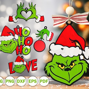 Könnte beinhalten: Eine grüne Figur mit gelben Augen und roter Weihnachtsmütze, mit verschiedenen grafischen Designs, darunter eine aus Händen geformte Herzform, der Text HO HO HO, der Text LOVE und ein hängendes Ornament mit rot-weiß gestreiftem Band.