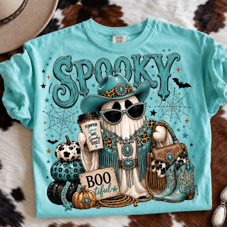 Western Halloween ghost design featuring bats, spiderwebs, patterned pumpkins, cowboy boots, turquoise stars, BOOtiful sign, and Pumpkin Spice and Spooky Vibes coffee cup.