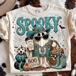 Western cowgirl Halloween design displayed on a shirt with a turquoise glam ghost, leopard-print details, spiderwebs, pumpkins, western accessories, and spooky typography.