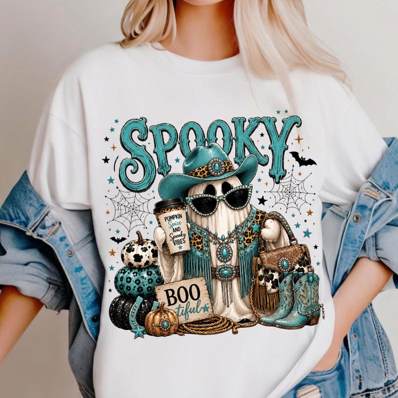 Western cowgirl Halloween design displayed on a shirt with a turquoise glam ghost, leopard-print details, spiderwebs, pumpkins, western accessories, and spooky typography.