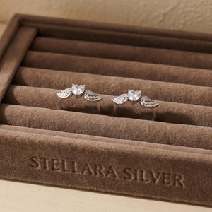 Elegant S925 sterling silver angel wing heart ring with high grade cubic zirconia, a refined minimalist ring and dainty crystal ring made for layering, stacking, and gifting, a meaningful promise ring and cute statement ring suitable for women of all ages.