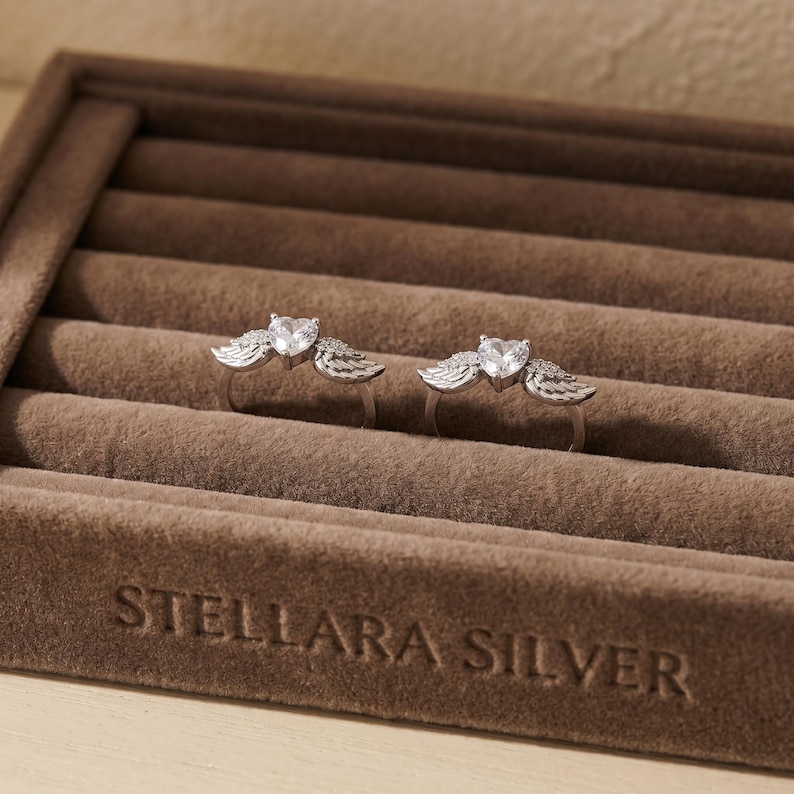 Elegant S925 sterling silver angel wing heart ring with high grade cubic zirconia, a refined minimalist ring and dainty crystal ring made for layering, stacking, and gifting, a meaningful promise ring and cute statement ring suitable for women of all ages.