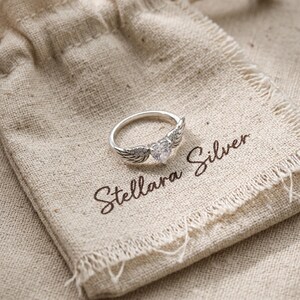 Heart wing ring in sterling silver featuring cubic zirconia crystals and a sparkling heart shaped stone, a premium choice among dainty rings and silver rings for women, ideal as promise rings, statement rings, friendship rings, or a charming pink heart ring gift.