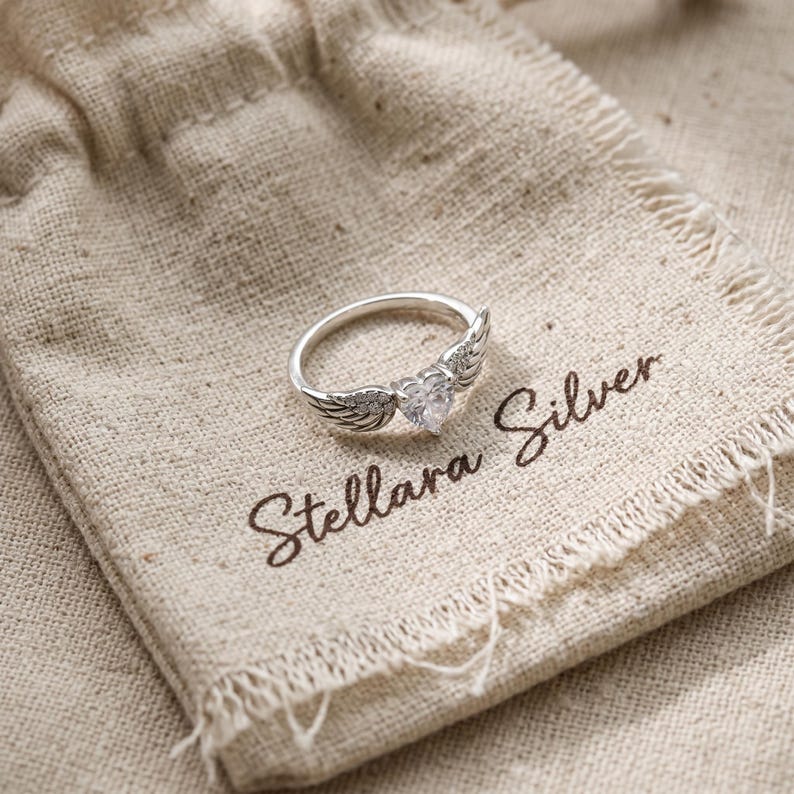 Heart wing ring in sterling silver featuring cubic zirconia crystals and a sparkling heart shaped stone, a premium choice among dainty rings and silver rings for women, ideal as promise rings, statement rings, friendship rings, or a charming pink heart ring gift.