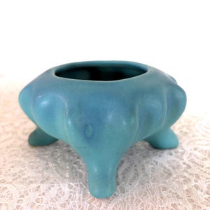 May include: A white ceramic mug with a black handle and the text "But First, Coffee" in a handwritten style. The mug is likely for hot beverages and has a glossy finish.