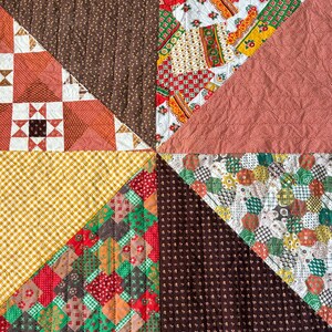 May include: A patchwork quilt featuring a variety of fabric patterns arranged in large triangular sections. The design includes brown floral prints, yellow gingham, red and green geometric squares, and a white fabric with colorful floral motifs.