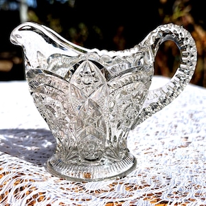 May include: A set of three ceramic mugs with a speckled, cream-colored glaze. Each mug features a different hand-painted floral design in shades of blue, green, and yellow. The mugs have a simple, rounded shape and a comfortable handle.