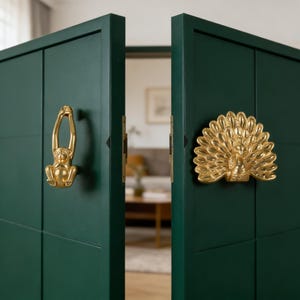 May include: Dark green cabinet doors with gold hardware. One door has a monkey-shaped handle, the other a peacock. The doors are ajar, showing a hint of the interior. The cabinet is likely made of wood.