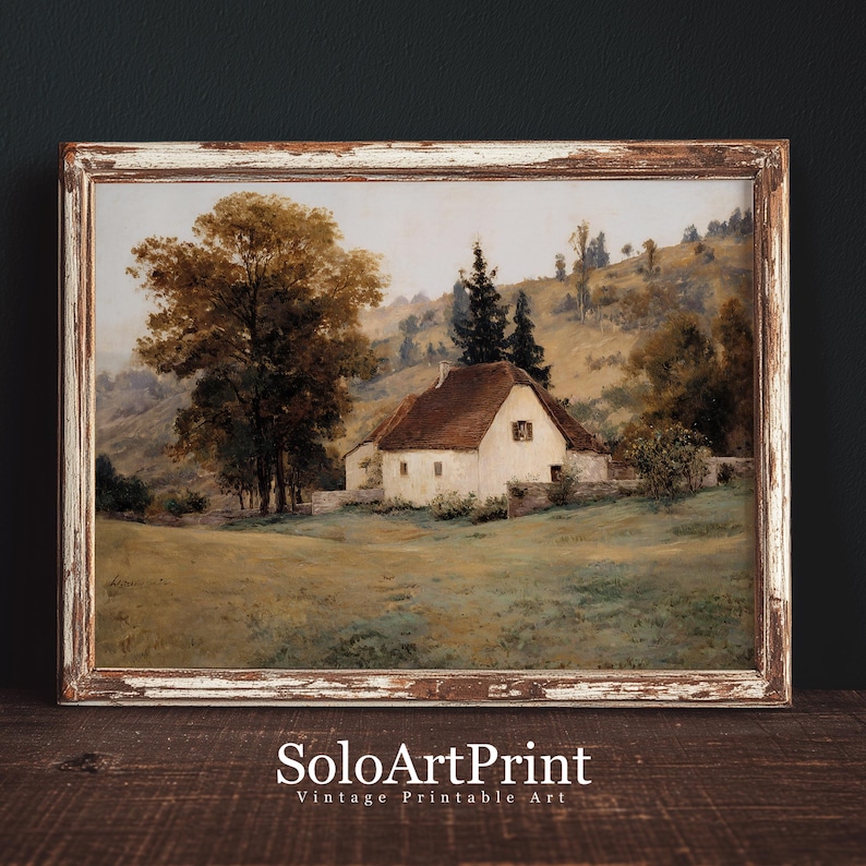 May include: A landscape painting in a distressed brown wooden frame depicting a white cottage with a brown roof nestled in a grassy field. A large tree stands to the left, with rolling hills and evergreen trees in the background. Text reads SoloArtPrint.