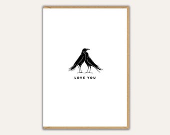 May include: A white card with a black illustration of two birds facing each other. The words "LOVE YOU" are printed in black below the birds. The card is set in a brown frame.