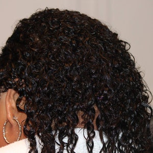 Puede incluir: Primer plano del cabello rizado casta&ntilde;o oscuro de una persona. El cabello est&aacute; mojado y parece estar peinado.