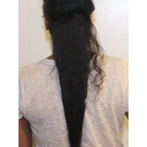 以下が含まれることがあります： 白いクリップでまとめられた、長い黒髪の女性。髪は非常に長く、腰まで届いています。
