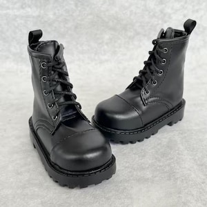 May include: A pair of black leather boots with a lace-up design. The boots have a rounded toe and a thick, textured sole. The boots are approximately 6 inches tall.