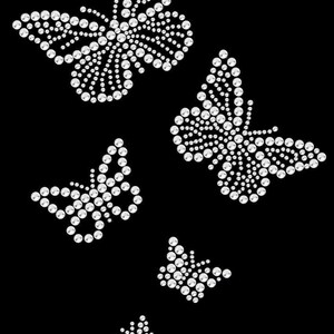 K&ouml;nnte beinhalten: Auf schwarzem Hintergrund ein Design aus mehreren Schmetterlingen. Jeder Schmetterling besteht aus zahlreichen kleinen, funkelnden, wei&szlig;en Strasssteinen, die einen schimmernden Effekt erzeugen. Die Schmetterlinge variieren in der Gr&ouml;&szlig;e und sind in einem dynamischen, aufw&auml;rts gerichteten Muster angeordnet.
