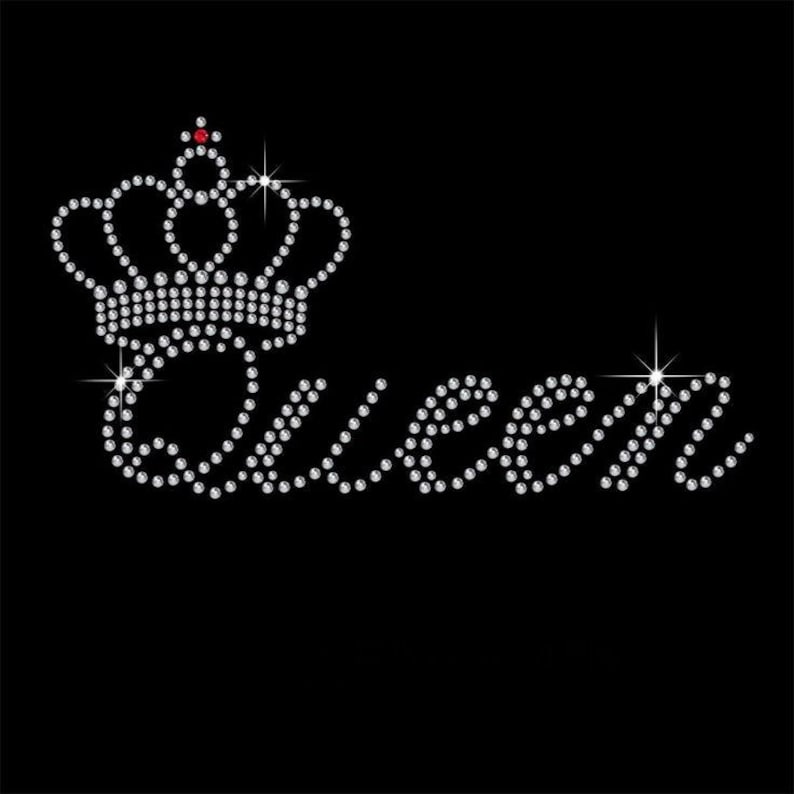 K&ouml;nnte beinhalten: Schwarzer Hintergrund mit dem Wort "Queen" aus funkelnden Strasssteinen. Eine Strasskrone mit einem einzelnen roten Edelstein befindet sich &uuml;ber dem Wort, mit Sterneneffekten.