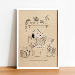 Puede incluir: Ilustraci&oacute;n en blanco y negro enmarcada de Snoopy sentado en un inodoro, leyendo un peri&oacute;dico. La escena del ba&ntilde;o incluye una estanter&iacute;a con plantas en macetas, un rollo de papel higi&eacute;nico y una alfombra peque&ntilde;a. La obra de arte est&aacute; en un marco blanco.