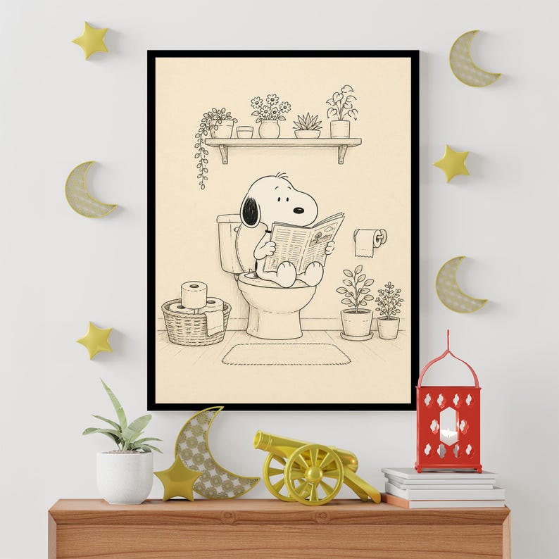 Puede incluir: Ilustraci&oacute;n en blanco y negro enmarcada de Snoopy sentado en un inodoro, leyendo un peri&oacute;dico. La escena del ba&ntilde;o incluye una estanter&iacute;a con plantas en macetas, un rollo de papel higi&eacute;nico y una cesta tejida con rollos adicionales. La obra de arte se exhibe en una pared con estrellas y lunas decorativas.