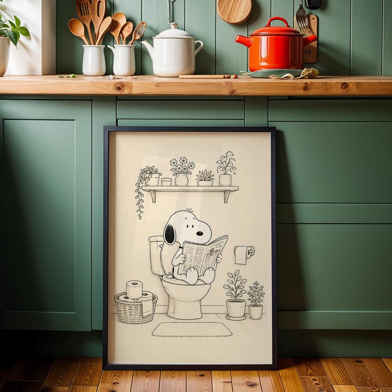 Puede incluir: L&aacute;mina art&iacute;stica enmarcada en negro que representa a Snoopy sentado en un inodoro, leyendo un peri&oacute;dico. La ilustraci&oacute;n en blanco y negro incluye una estanter&iacute;a con plantas en macetas, un rollo de papel higi&eacute;nico y una peque&ntilde;a alfombra. Una pieza caprichosa para un ba&ntilde;o o la decoraci&oacute;n del hogar.