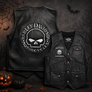 May include: A black leather vest featuring a large embroidered Harley-Davidson skull logo on the back. The front displays a smaller skull graphic, the text Harley-Davidson, a chest pocket, and two lower pockets with snap closures and metal buttons.