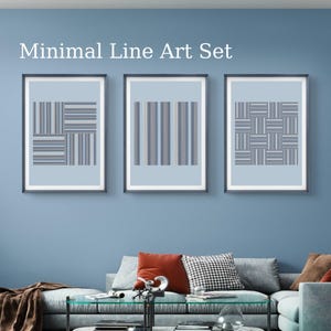 May include: Three framed minimalist line art prints. Each print features a different geometric design in shades of blue, gray, and white against a light blue background. The text "Minimal Line Art Set" is at the top.