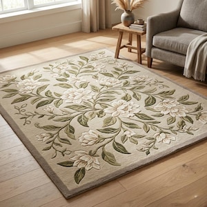 Pode incluir: Tapete bege com padrão floral. O tapete apresenta um desenho central de flores brancas e folhas verdes, com uma borda bege mais escura. Está colocado sobre um chão de madeira. Dimensões aproximadas: 200 cm x 300 cm.