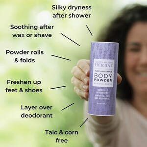 Puede incluir: Un envase cil&iacute;ndrico de polvos corporales con una etiqueta lavanda se sostiene frente a un fondo verde borroso. La etiqueta dice "ORA'S AMAZING HERBAL BODY POWDER" y enumera beneficios como "Silky dryness after shower".