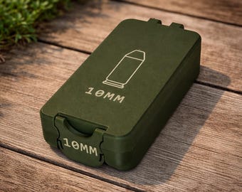 May include: An olive green rectangular container with a hinged lid. The lid features a white outline of a bullet and the text "10MM". The same text is also on the front of the container. The container is on a wooden surface.