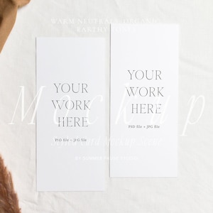 May include: A flat lay mockup scene featuring two white rectangular cards with the text "YOUR WORK HERE". The cards are on a white surface with a brown fabric and dried plants in the background. The text "PSD file + JPG file" is also visible.