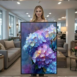 Op de afbeelding: Een ingelijste kunstdruk met een close-up van een hortensiaboeket. Het kunstwerk toont een mix van blauwe, paarse en gele tinten, met een textuurrijke, schilderachtige stijl. Het zwarte frame voegt een moderne touch toe.
