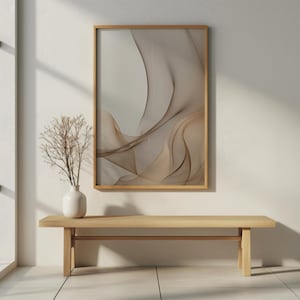 Könnte beinhalten: Abstrakter Kunstdruck in einem Holzrahmen mit fließenden, geschichteten Formen in Beige- und Brauntönen. Das Kunstwerk hängt über einer hellen Holzbank und einer weißen Vase mit getrockneten Zweigen.