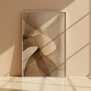 May include: Framed abstract art print featuring a layered design in shades of brown and beige. The artwork has a watercolor effect with flowing lines and shapes, creating a sense of depth and movement. The print is displayed in a white frame.
