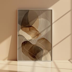 Könnte beinhalten: Abstrakter Kunstdruck mit überlappenden organischen Formen in Braun-, Beige- und Cremetönen. Feine weiße Linien fließen über das Design und erzeugen ein Gefühl von Tiefe und Bewegung. Das Kunstwerk ist mit einem weißen Rahmen versehen.