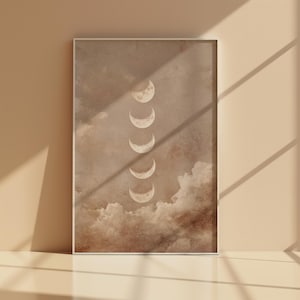 Könnte beinhalten: Gerahmter Druck mit Mondphasen. Das Kunstwerk zeigt eine Reihe von Mondphasen, die vertikal vor einem Hintergrund aus Wolken in Braun- und Beigetönen angeordnet sind. Das Design ist minimalistisch und erzeugt eine ruhige und beruhigende Atmosphäre.