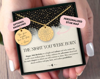 May include: A black box with a gold necklace inside. The necklace has two pendants, one with a star map and the other with an inscription that reads "You shine brighter than the stars x Laura". The box also has a pink label that says "Personalized Star Map" and another pink label that says "Optional Engraving". The text on the box reads "The Night You Were Born Happy 30th Birthday to a bright and radiant soul who makes the world a more brilliant place. Today, embrace the adventure ahead and this new chapter in which you will continue to shine. May your journey ahead overflow with joy, love, and endless possibilities."
