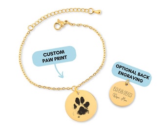 Könnte beinhalten: Goldkette Armband mit einem runden Anhänger mit einem individuellen Pfotenabdruck. Die Rückseite des Anhängers kann optional mit dem Text "03.08.2023 Rosie Mae" graviert werden.