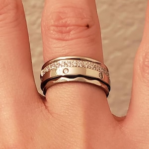 Peut inclure: Une tasse en céramique blanche avec une anse noire et l'inscription "But First, Coffee" en gras noir. La tasse est posée sur un fond flou, suggérant un cadre chaleureux.