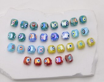 Conjunto de 10 contas espaçadoras de vidro em formato cilíndrico, coloridas e com detalhes de olho, ideais para confecção de bijuterias, pulseiras e outros artesanatos.