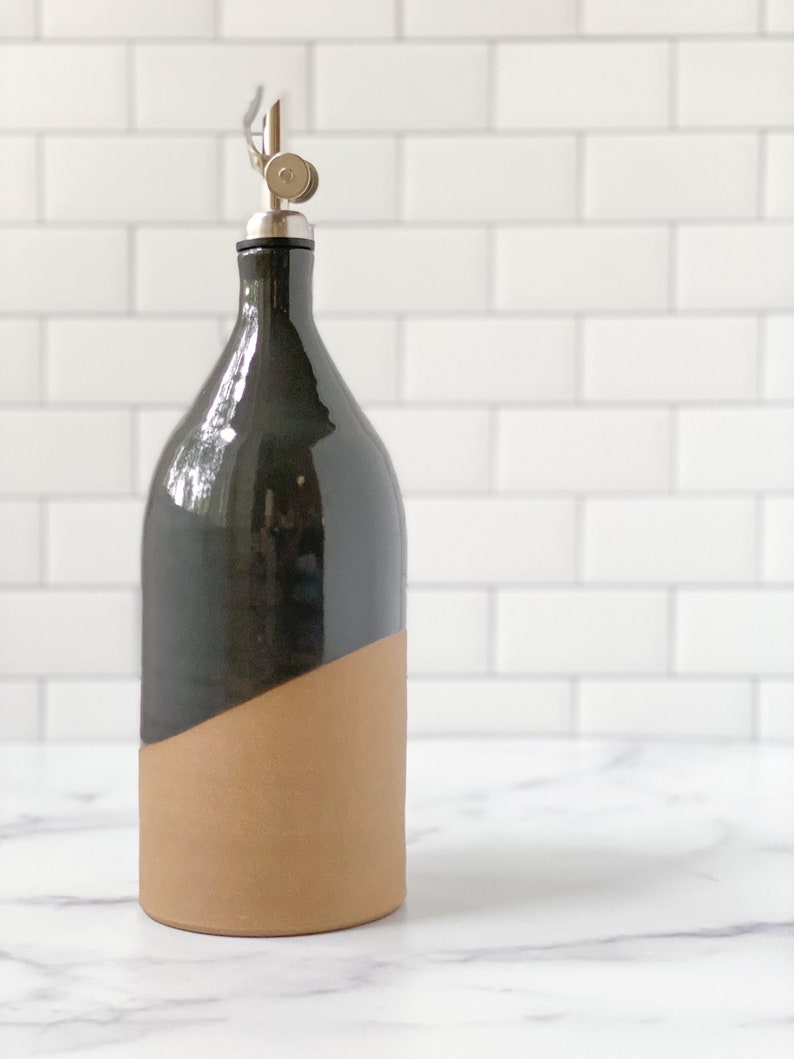 K&ouml;nnte beinhalten: Eine schwarze und braune Keramikflasche f&uuml;r &Ouml;l und Essig mit einem silbernen Ausgie&szlig;er.